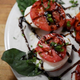Caprese (tomato, mozzarella, basil, balsamic drizzle) plated and ready to be served
